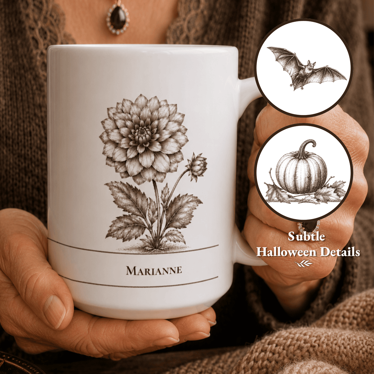A person holds a white ceramic mug with a detailed black botanical illustration of a dahlia flower and her name printed below. Two circular inset callouts on the right show subtle Halloween-themed details, including a bat and a pumpkin.
