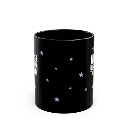 Side view of black ceramic 11oz mug with a starry night sky design, featuring white text on the sides and small light blue stars scattered across the surface. Mug is shown against a plain white background.
