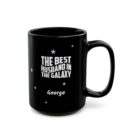 Black 15oz mug with small light blue stars and white text 'Best Husband in the Galaxy' with a personalize name below. Right handle view. Mug is placed on a white background