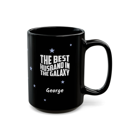 Black 15oz mug with small light blue stars and white text 'Best Husband in the Galaxy' with a personalize name below. Right handle view. Mug is placed on a white background
