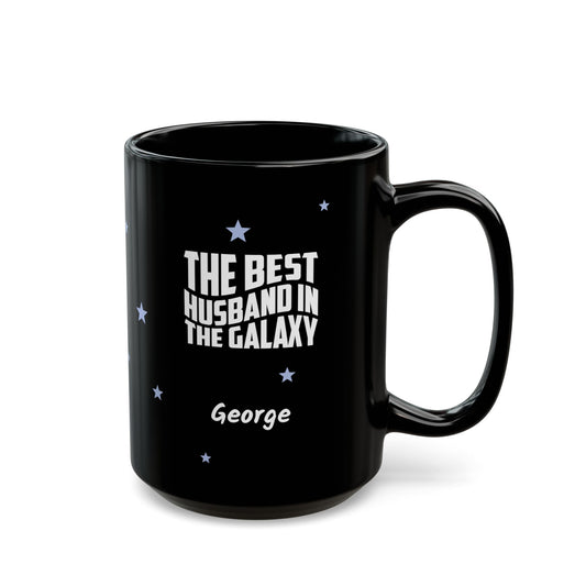 Black 15oz mug with small light blue stars and white text 'Best Husband in the Galaxy' with a personalize name below. Right handle view. Mug is placed on a white background