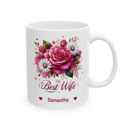 A white ceramic 11oz mug featuring a colorful floral design with pink roses, white daisies, and green leaves. Below the flowers, the text reads 'The Best Wife' in a cursive font, with 'Samantha' and small red hearts printed underneath. Right handle view.