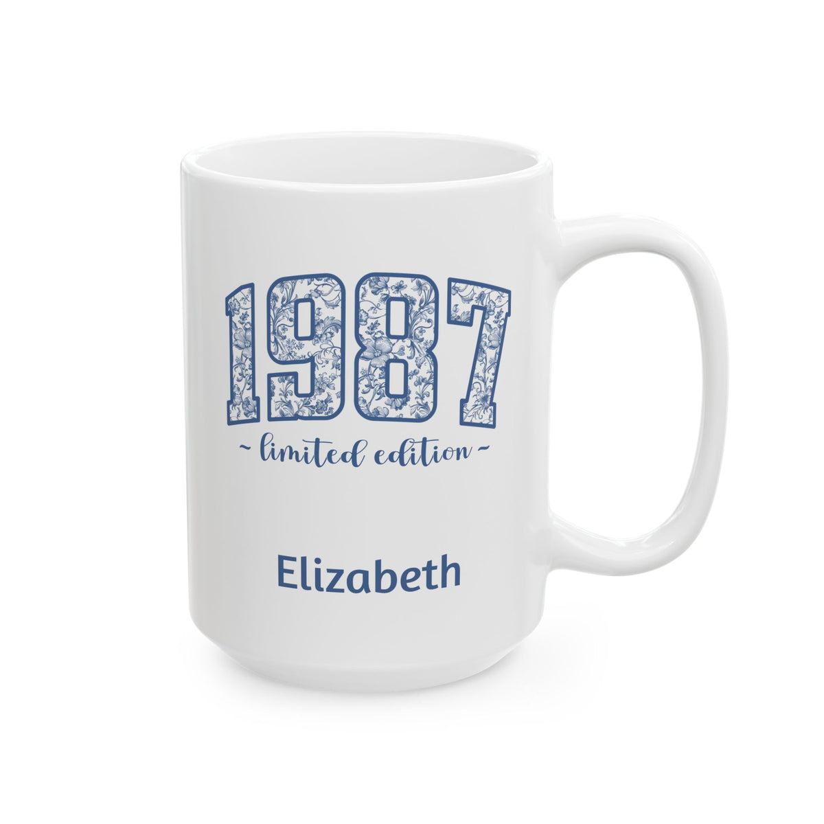 A white ceramic 15oz mug with a blue floral patterned '1987' design, featuring the text '~ limited edition ~' and the name 'Elizabeth' printed below, shown on a plain white background. Right handle view.