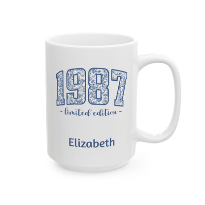 A white ceramic 15oz mug with a blue floral patterned '1987' design, featuring the text '~ limited edition ~' and the name 'Elizabeth' printed below, shown on a plain white background. Right handle view.