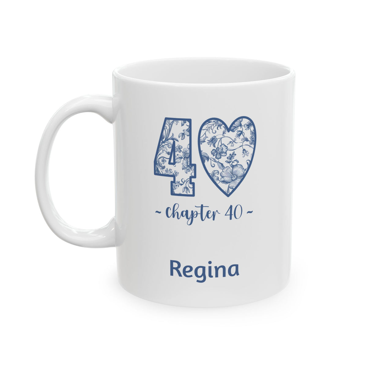A white ceramic 11oz mug with a blue '40 chapter 40' graphic featuring a floral toile pattern inside the heart and number, with the name 'Regina' printed below in blue, shown on a plain white background. Left handle view.