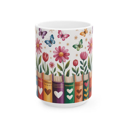 A white ceramic mug decorated with a colorful pattern of flowers, butterflies, and book spines with hearts, shown on a clean white background. No handle view.