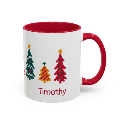 A white ceramic 11oz mug with a red interior and red handle, decorated with seven colorful Christmas trees around the mug and the name 'Timothy' printed in red near the bottom. Right handle view.