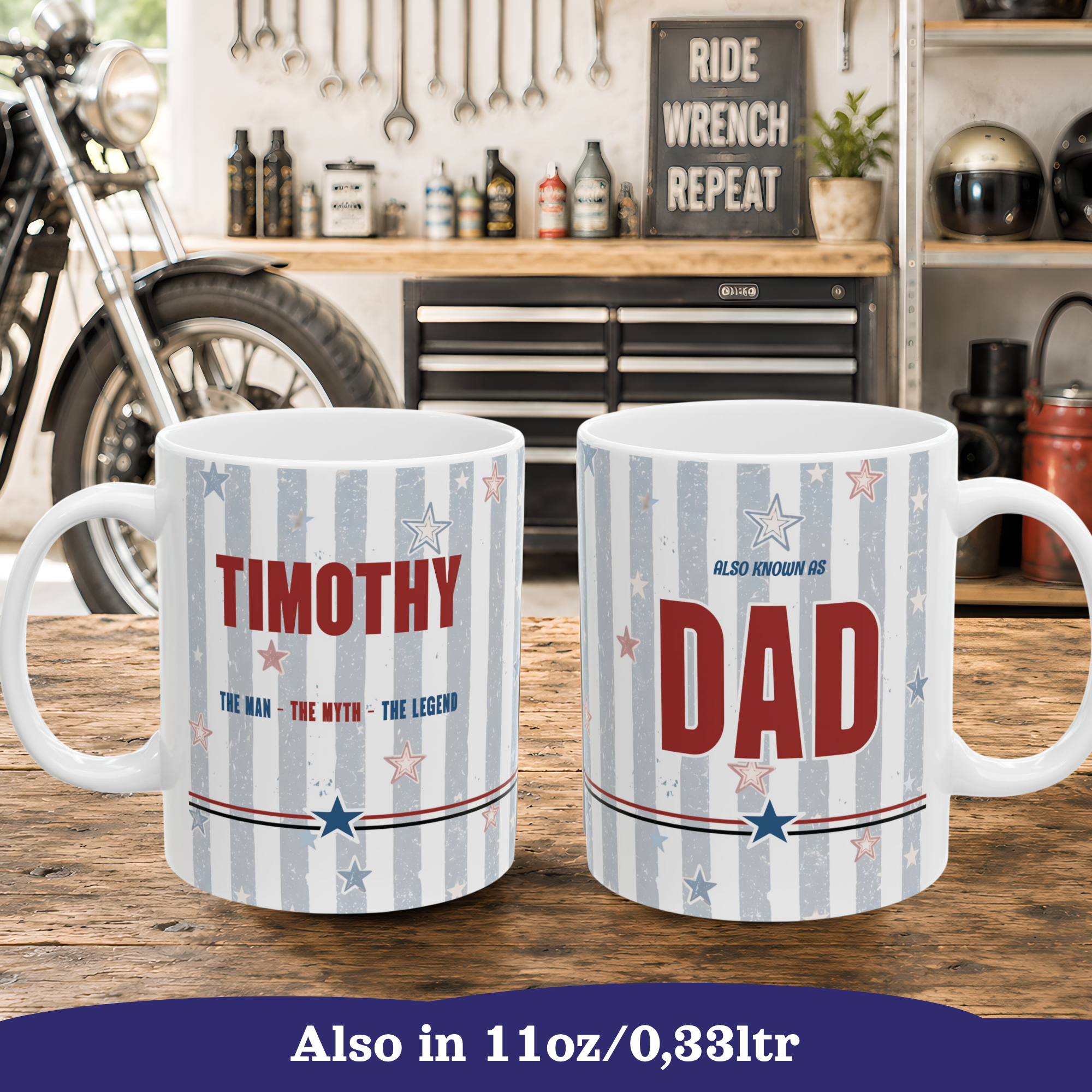 Two white ceramic 11oz mugs with a patriotic blue, red, and white striped design featuring dad's name and 'DAD' with stars, shown on a wooden table with a workshop and motorcycle in the background. 