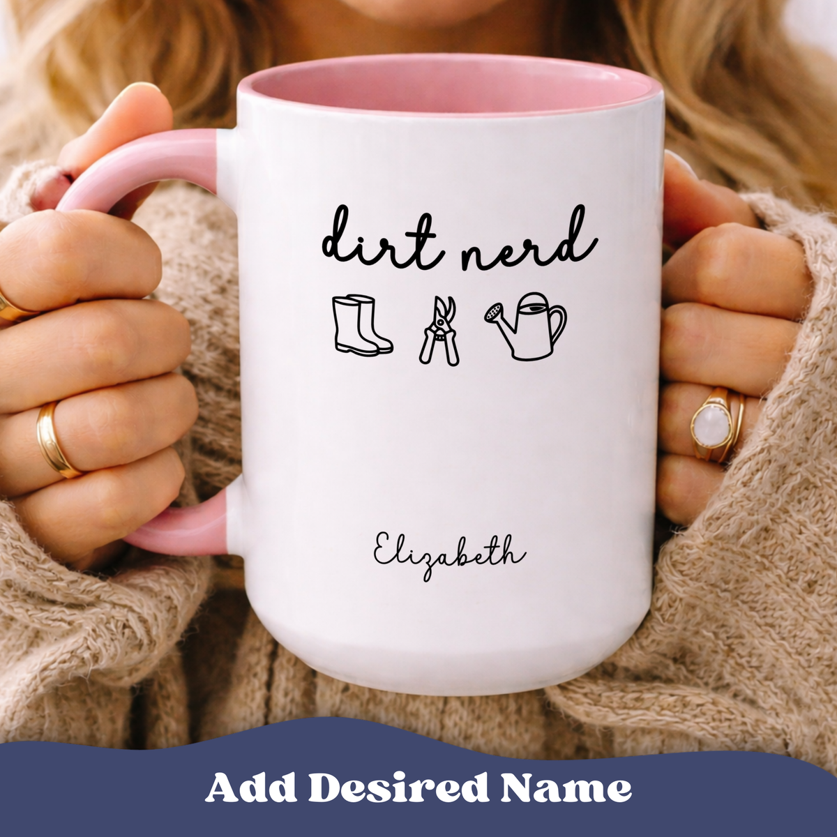 Person holding Dirt Nerd accent mug with pink interior, rain boots, pruners, a watering can graphics, personalized name 'Elizabeth'.