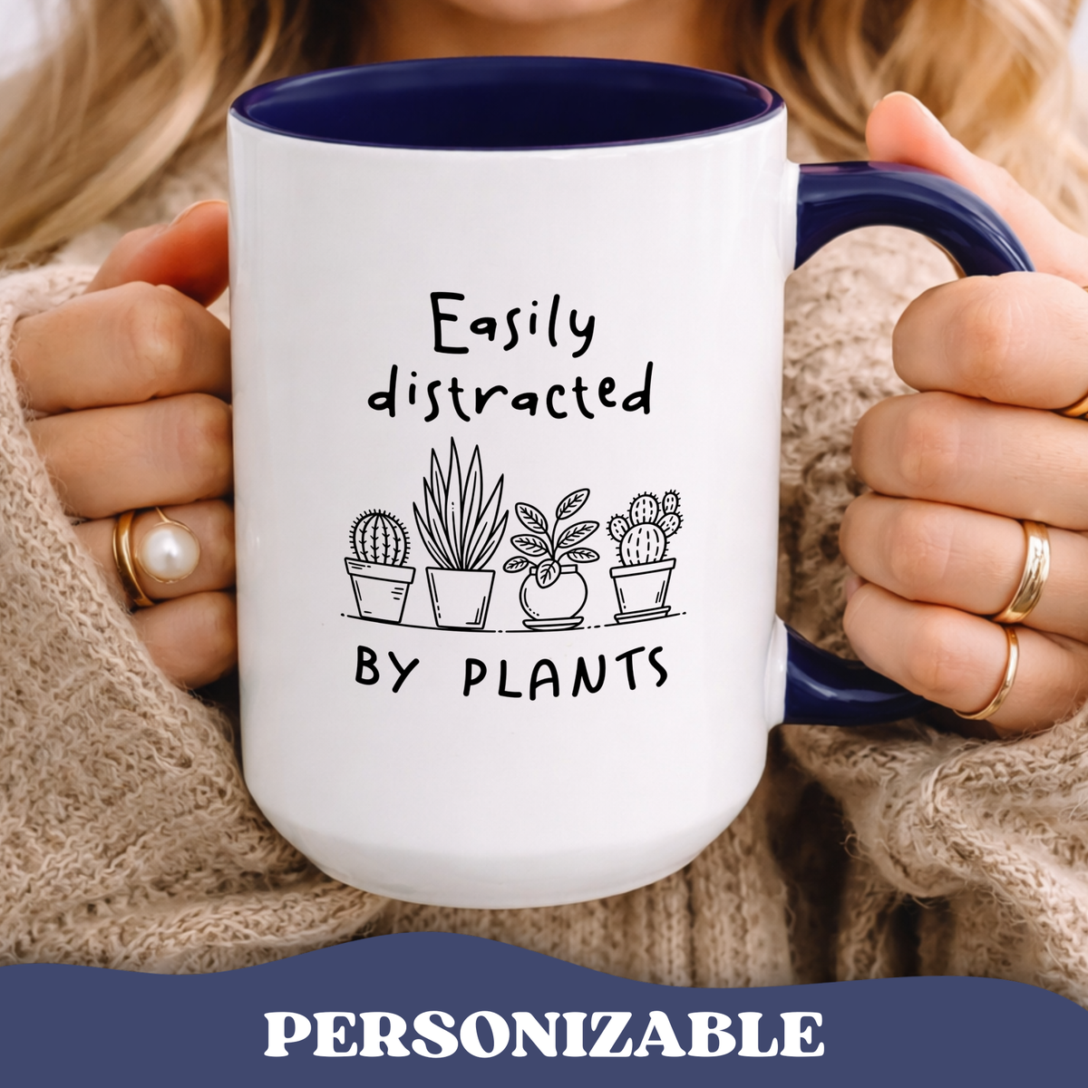 Person holding Easily Distracted by Plants accent mug with navy interior and cacti graphic.