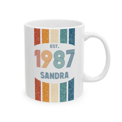 A white ceramic 11oz mug featuring a retro-style graphic with vertical grunge-textured stripes in orange, beige, and teal, with the text 'EST. 1987 SANDRA' printed on the front. Right handle view.
