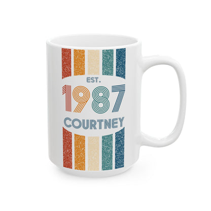 A white ceramic 15oz mug with a retro-style vertical striped design in orange, beige, and teal, featuring the text 'EST. 1987 COURTNEY' printed on the front. Right handle view.