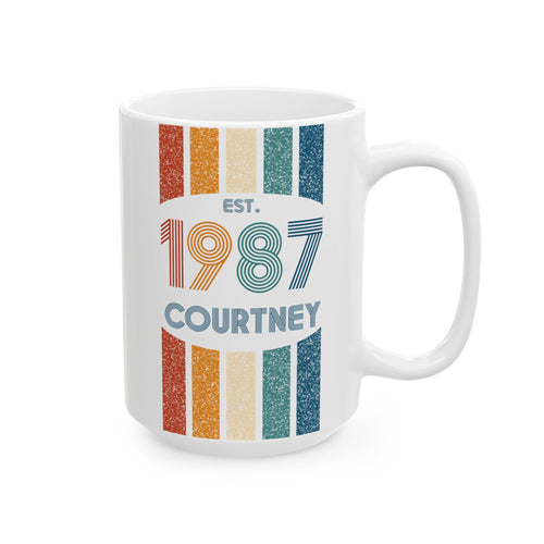 A white ceramic 15oz mug with a retro-style vertical striped design in orange, beige, and teal, featuring the text 'EST. 1987 COURTNEY' printed on the front. Right handle view.