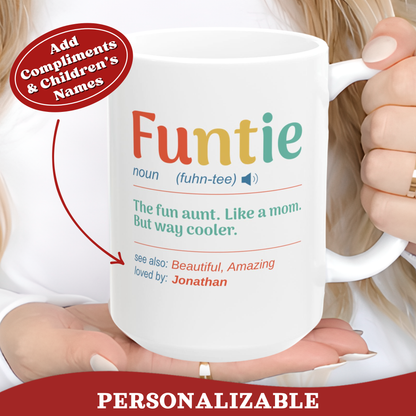 A white ceramic 15oz mug with a colorful dictionary-style definition of the word 'Funtie' being held by a person. The mug features the text 'noun (fuhn-tee) The fun aunt.