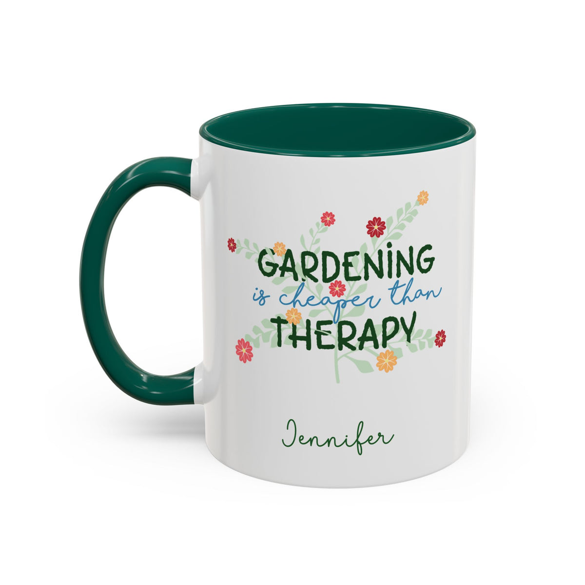 A white ceramic 11oz mug with a dark green handle and interior, featuring the printed phrase 'GARDENING is cheaper than THERAPY' in green and blue script with small colorful flowers, and the name 'Jennifer' in green cursive below. Left handle view.