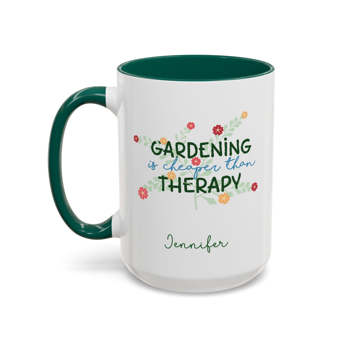 A white ceramic 15oz mug with a dark green handle and interior, featuring the printed phrase 'GARDENING is cheaper than THERAPY' in green and blue script with small colorful flowers, and the name 'Jennifer' in green cursive below. Left handle view.