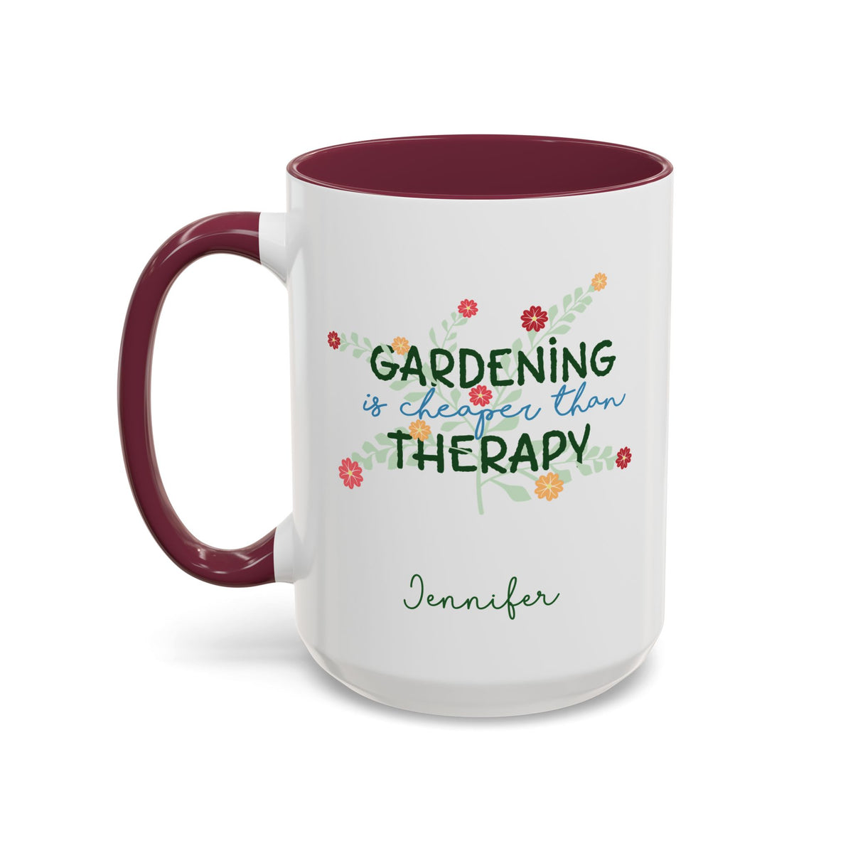 A white ceramic 15oz mug with a maroon colored handle and interior, featuring the printed phrase 'GARDENING is cheaper than THERAPY' in green and blue script with small colorful flowers, and the name 'Jennifer' in green cursive below. Left handle view.