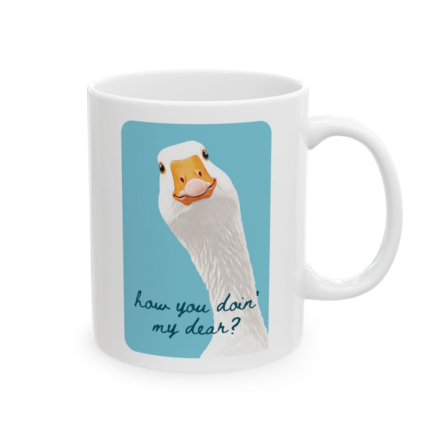 A white ceramic 11oz mug featuring a graphic illustration of a white goose with an orange beak on a light blue background, with the personalizable text 'good morning kimberly' written below in dark blue script. Right handle view.