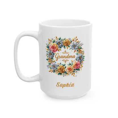 A white ceramic 15oz mug with a colorful floral wreath design featuring the word 'Grandma' in gold color script, and the name 'Sophia' printed below in gold, shown on a plain white background. Left handle view.
