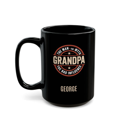 Black 15oz mug with 'Grandpa: The Man, The Myth, the Bad Influence' text placed in a circle, and personalized name below. Left handle view. Mug is placed on a white background