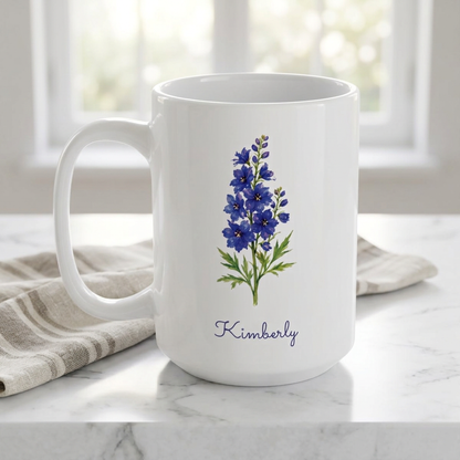 Larkspur birth flower personalized ceramic mug, styled on a white marble table with linen napkin, window in the background, bright light.