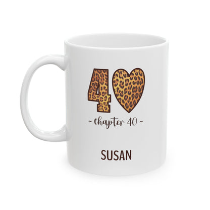 A white ceramic 11oz mug with a custom design celebrating a 40th birthday. The design features a leopard print '40' and heart symbol with 'chapter 40' text, and the name 'SUSAN' printed below in brown. Left handle view.