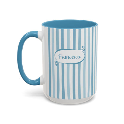 A white ceramic 15oz mug with vertical light blue stripes, a solid blue handle and interior, and a blue label on the front that reads 'Francesca'. Left handle view.