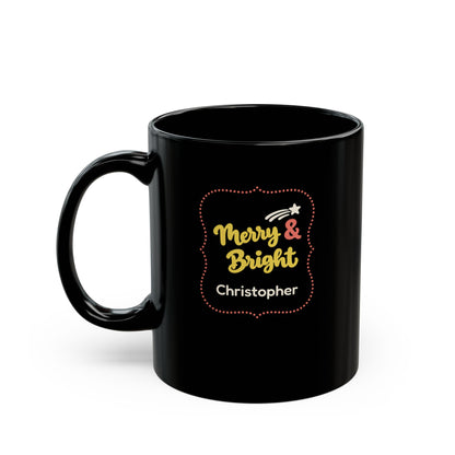 Glossy black 11oz mug with yellow and coral red design with text 'Merry & Bright' in thick yellow script lettering and a personalizable name. Left handle view.