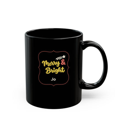 Glossy black 11oz mug with yellow and coral red design with text 'Merry & Bright' in thick yellow script lettering and a personalizable name. Right handle view.