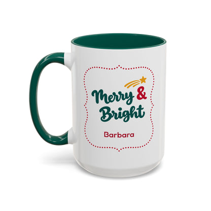 A white ceramic 15oz mug with a dark green handle and interior, featuring a festive graphic in thick script lettering that reads 'Merry & Bright' with a red dotted border, a small yellow shooting star, and the name 'Barbara' printed below. Left handle view.