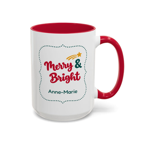A white ceramic 15oz mug with a red interior and red handle, featuring a 'Merry & Bright' holiday graphic in bold red script lettering, and the personalized name 'Anne-Marie' printed on the front, set against a plain white background. Right handle view.