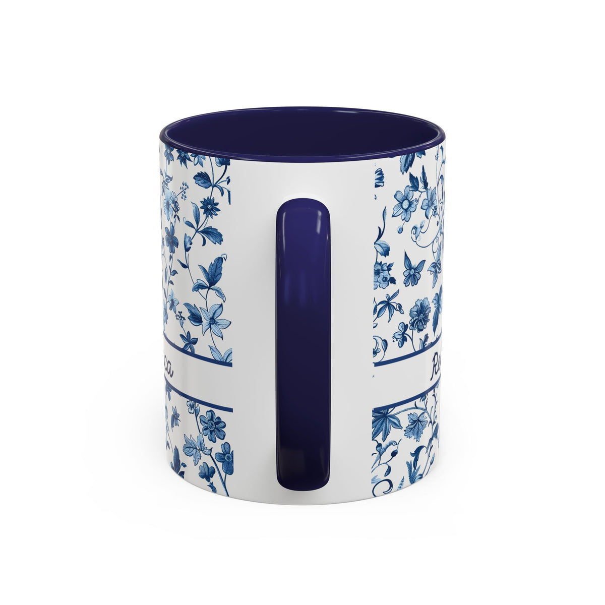 A white ceramic 11oz mug with a blue floral and butterfly pattern on the exterior, featuring a solid dark blue interior and a matching dark blue handle, shown on a plain white background. View of the handle.