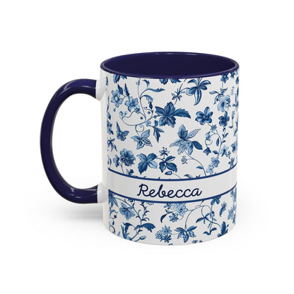 A white ceramic 11oz mug with a navy blue floral chinoiserie pattern, a navy blue handle and interior, and a white band around the middle featuring the name 'Samantha' in script. Left handle view.