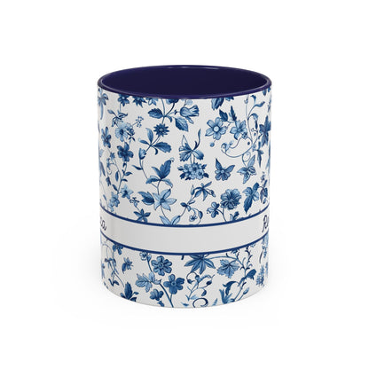 A ceramic 11oz cup with a blue floral chinoiserie pattern on a white exterior and a solid dark blue interior, shown against a plain white background. Handle not visible.