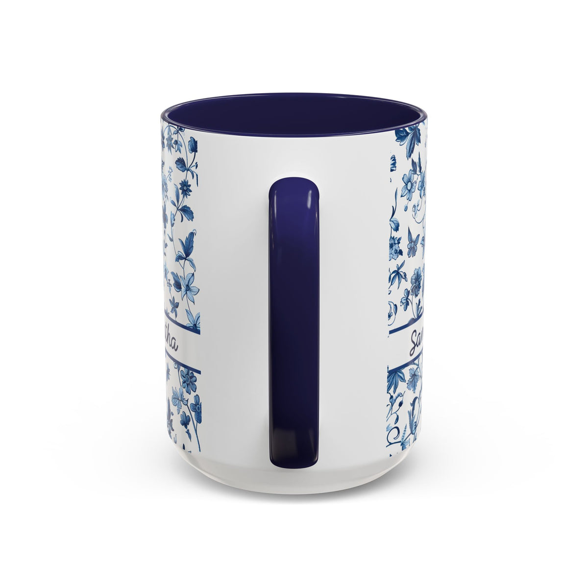 A white ceramic 15oz mug with a dark blue interior, a dark blue handle, and blue floral patterns printed on the sides. View of the handle.