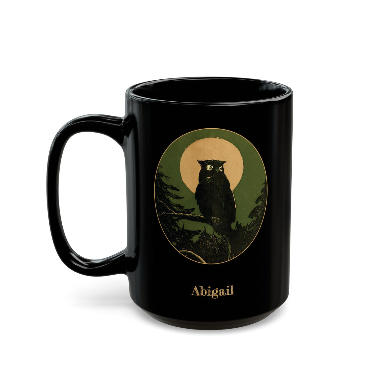 A black ceramic 15oz mug featuring a circular vintage-style owl illustration in green, gold color, and black, with the name 'Abigail' printed below in a gold-like color, shown on a white background. Left handle view.
