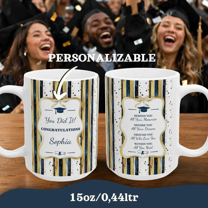 Two personalized graduation mugs on a table with celebrating students in the background