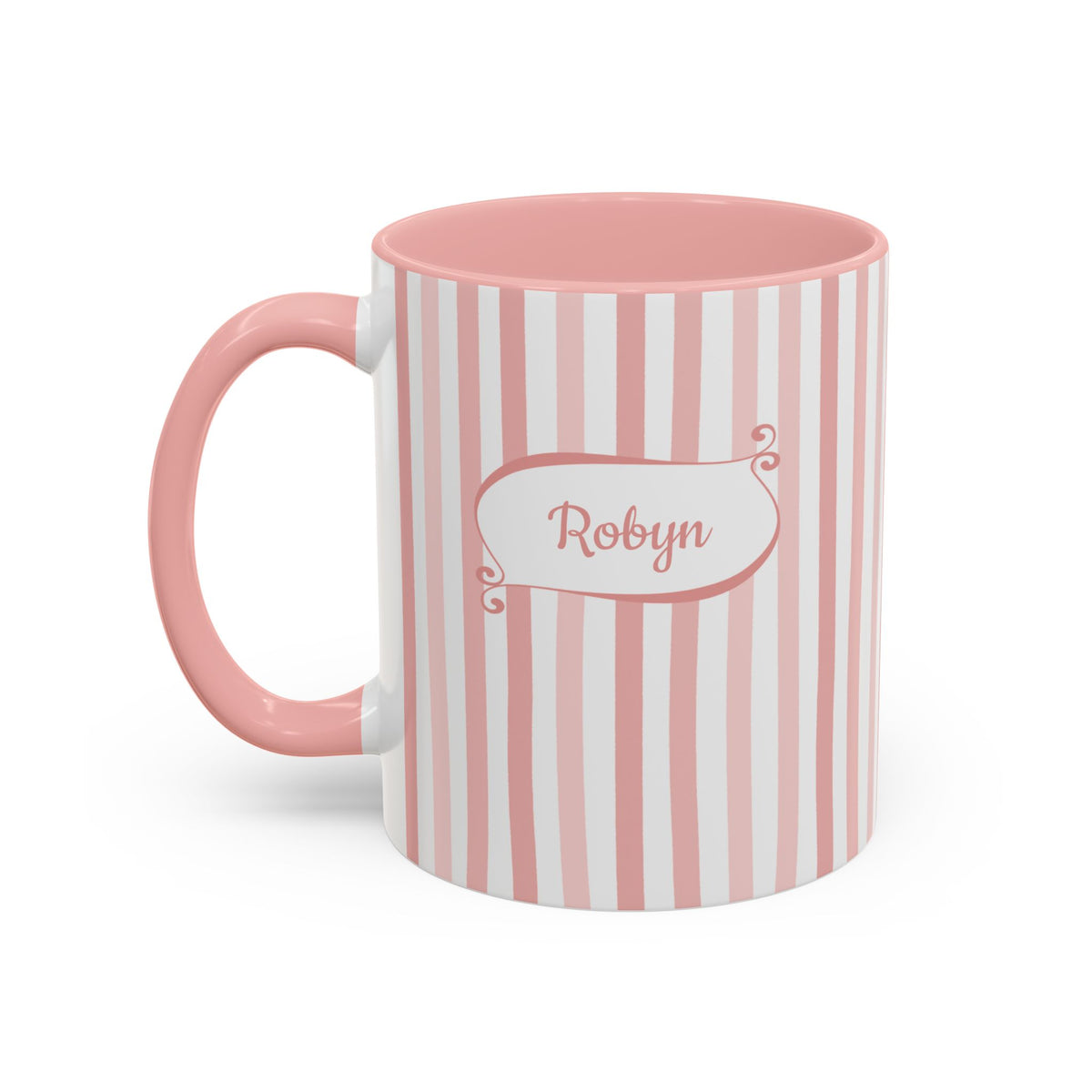 A pink and white vertically striped white ceramic 11oz mug with a pink handle and interior, featuring a white label on the front with the name 'Robyn' in pink script. Left handle view.