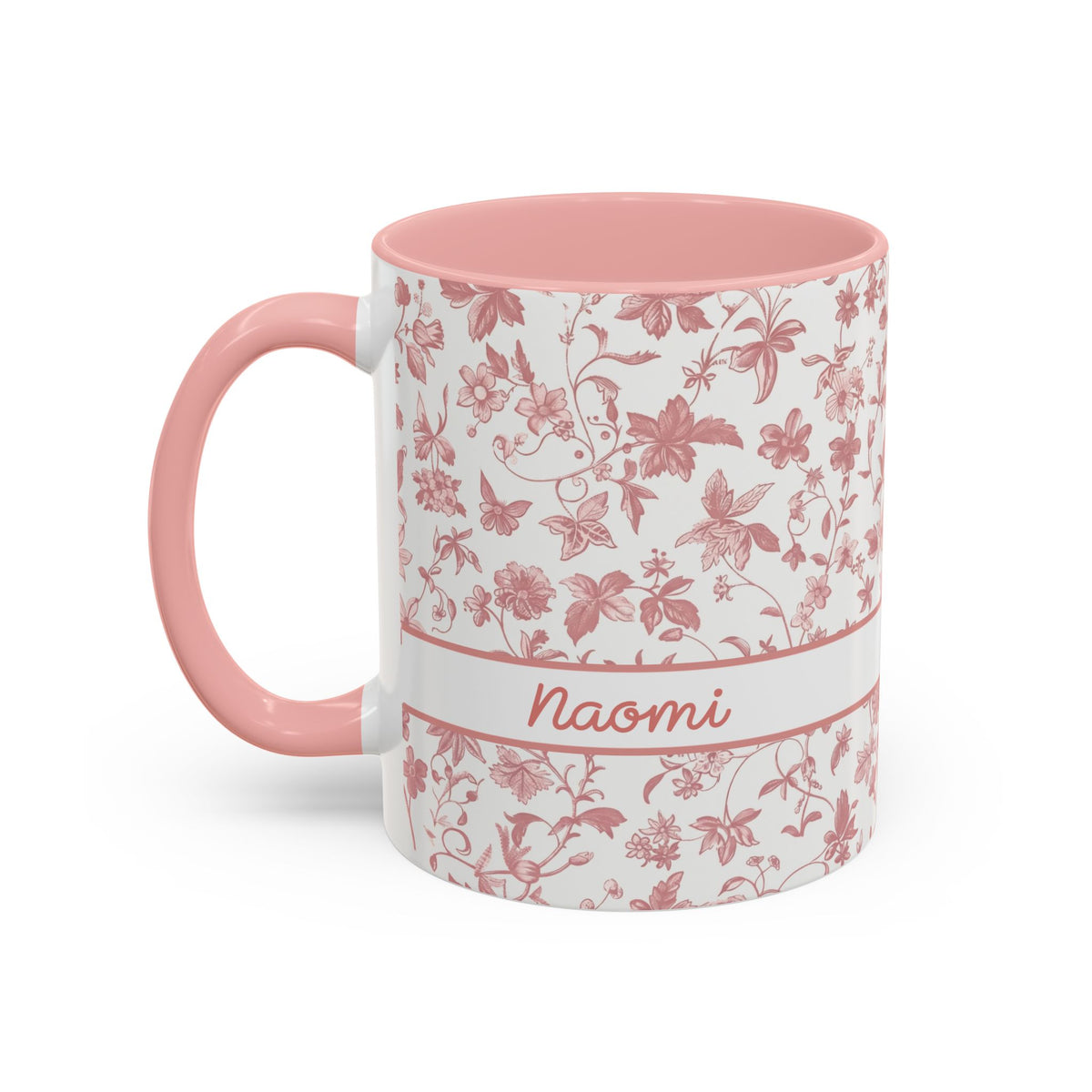 A white ceramic 11oz mug with a pink floral chinoiserie pattern, a pink handle, and a pink interior. A white band around the middle features the name 'Joanna' in pink script. Left handle view.