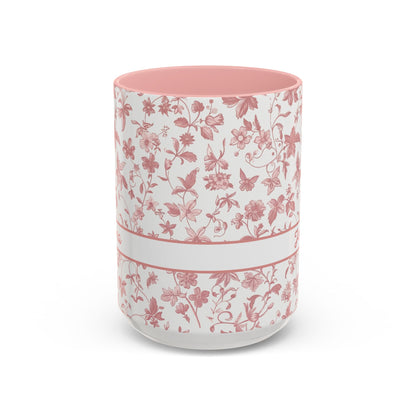 A white ceramic 15oz mug with a pink floral chinoiserie pattern, a pink handle, and a pink interior. A white band around the middle. Handle not visible.