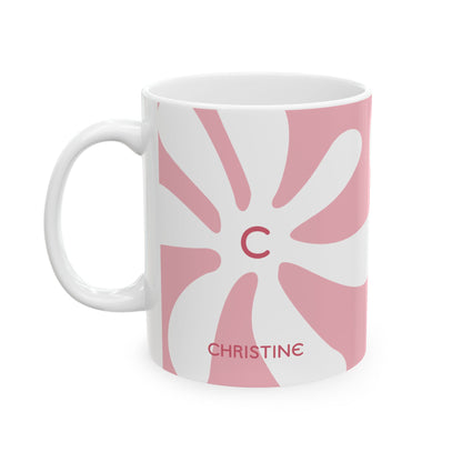 A white ceramic 11oz mug featuring a pink retro sunburst design with a red monogram letter 'C' in the center and the name 'CHRISTINE' printed in red near the bottom. Left handle view.