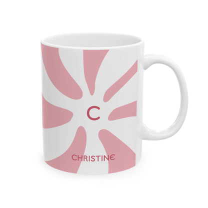 A white ceramic 11oz mug featuring a pink retro sunburst design with a red monogram letter 'C' in the center and the name 'CHRISTINE' printed in red near the bottom. Right handle view.