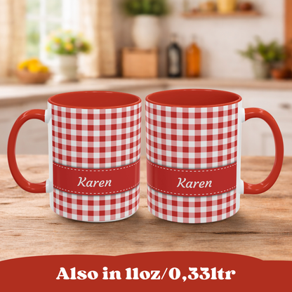 Two red and 11oz white gingham mugs with red handles and interiors, each wrapped in a red band reading 'Karen,' shown on a wooden table with a blurred kitchen background. A red banner at the bottom says 'Also in 11oz/0,331tr'.