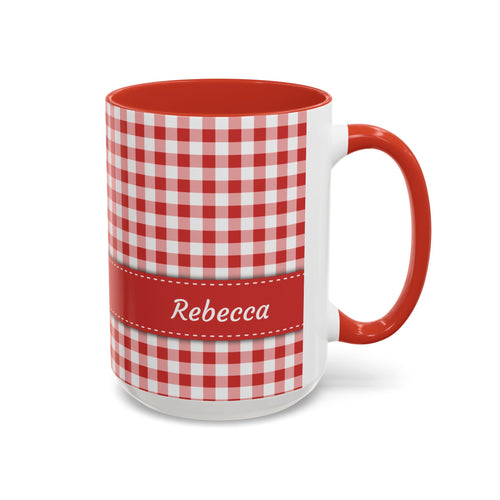 A white ceramic 15oz mug with a red and white gingham check pattern, a solid red handle and interior, and a red horizontal band around the middle featuring the name 'Rebecca' in white script. Right handle view.