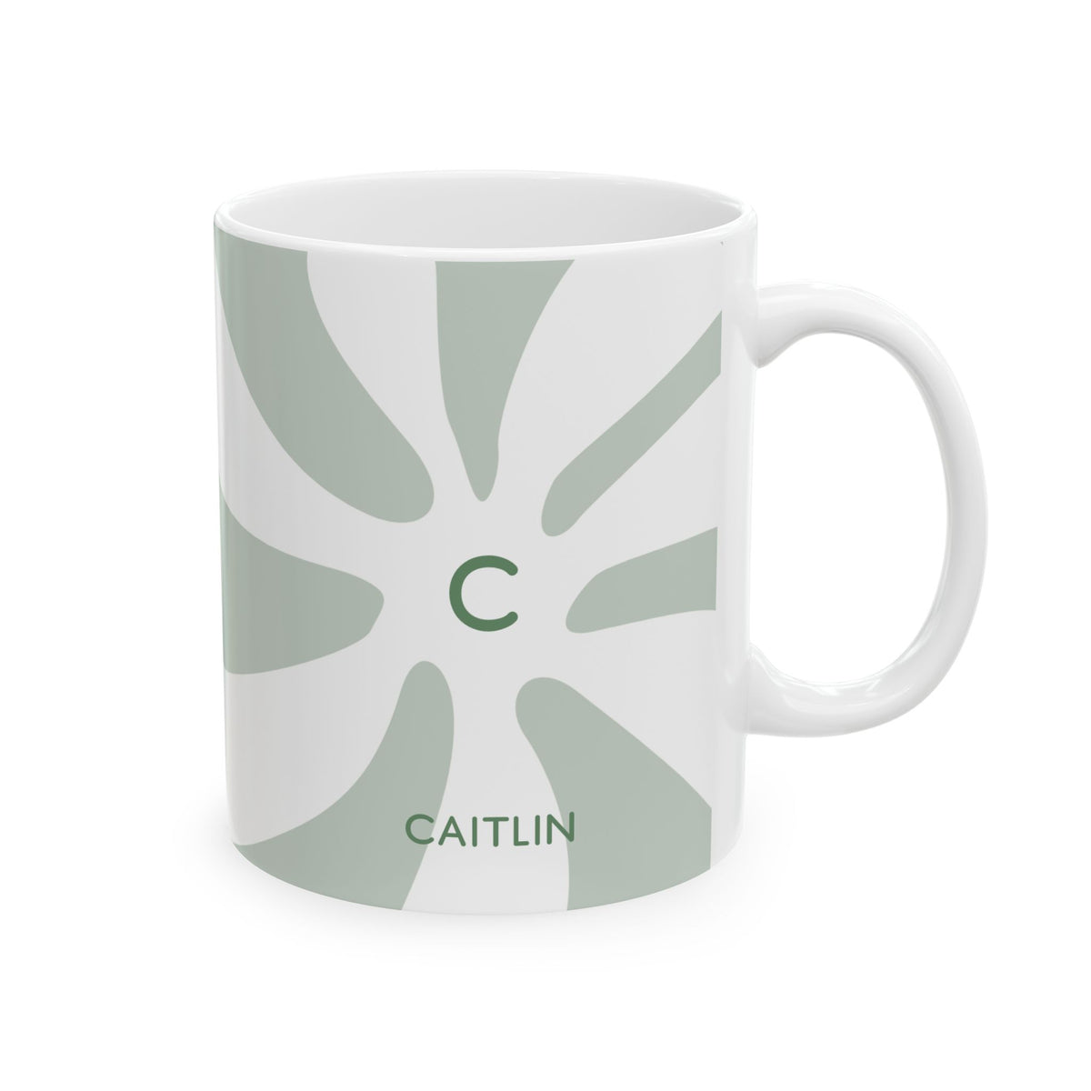 A white ceramic 11oz mug featuring a sage green sunburst pattern, a green letter 'C' in the center, and the name 'CAITLIN' printed below, shown on a clean white background. Right handle view.