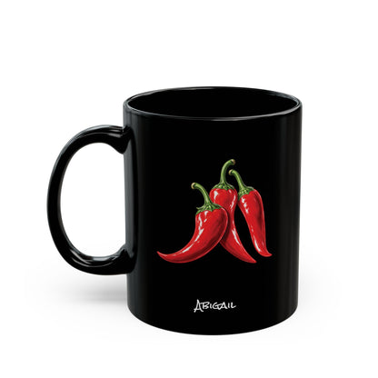 A black ceramic 11oz mug featuring a graphic of three red chili peppers with green stems and the name 'ABIGAIL' printed in white script below, set against a plain white background.