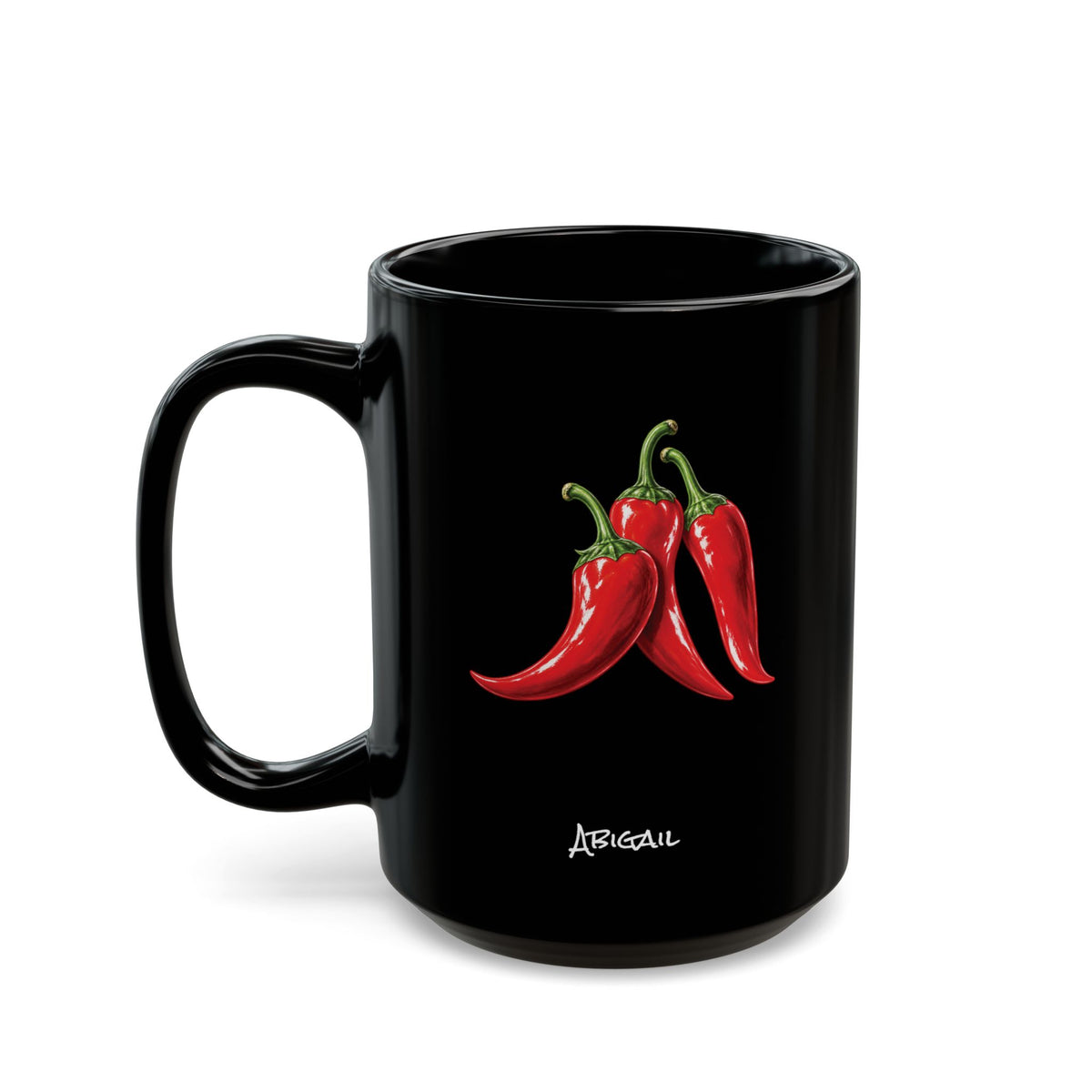 A glossy black ceramic 15oz mug featuring a graphic illustration of three red chili peppers with green stems and the name 'Abigail' printed in white script below, set against a plain white background.