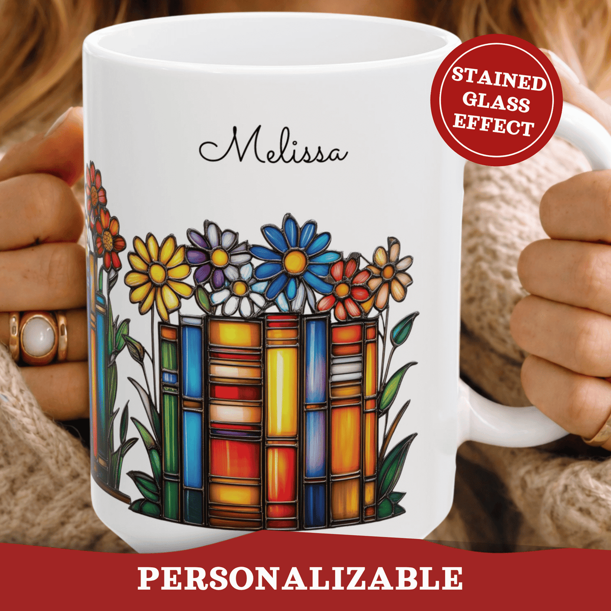 A white ceramic mug with a stained-glass-style book and flower design, held by two hands wearing a beige knit sweater. The mug is personalized with the name 'Melissa' in black script.
