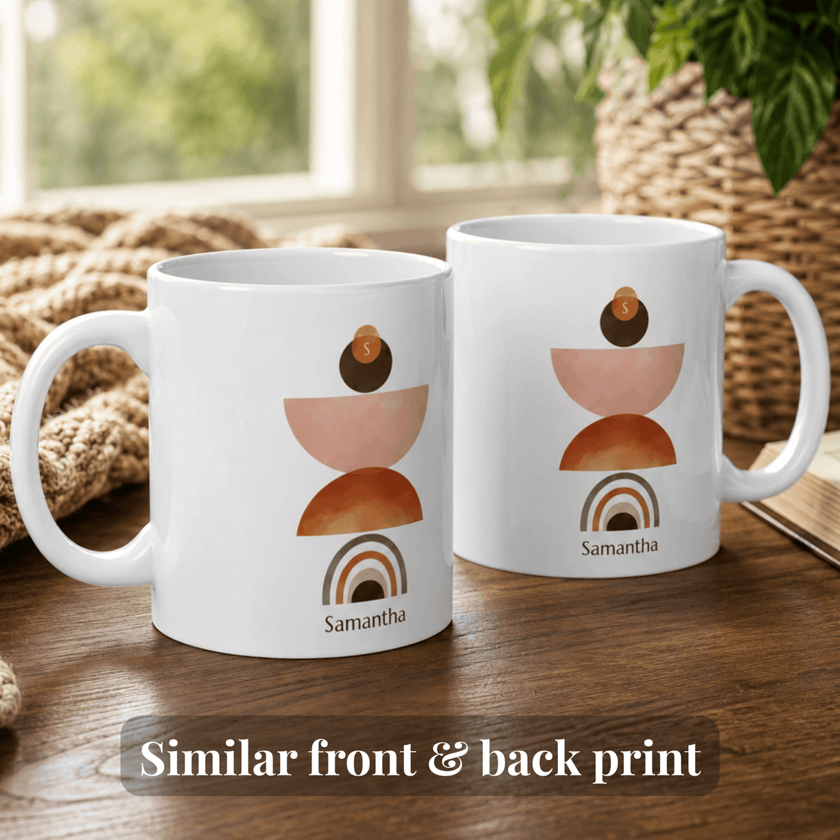 Two white ceramic 11oz mugs with a stacked geometric art print in terracotta, peach, and brown, featuring the name 'Samantha' and a small coin detail, displayed on a wooden table with a cozy background.