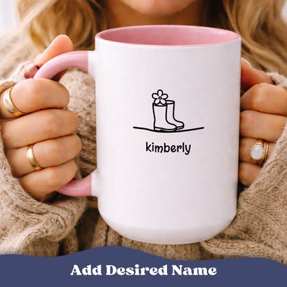 Person holding The Good Life accent mug with pink interior, boot and sprout graphic, personalized name 'Kimberly'.